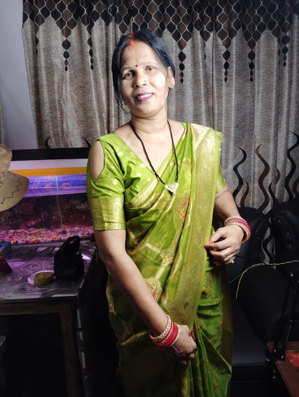 Maa — the founder and first seller of MadeByHer — smiling in a green saree at home in Aurangabad, Bihar